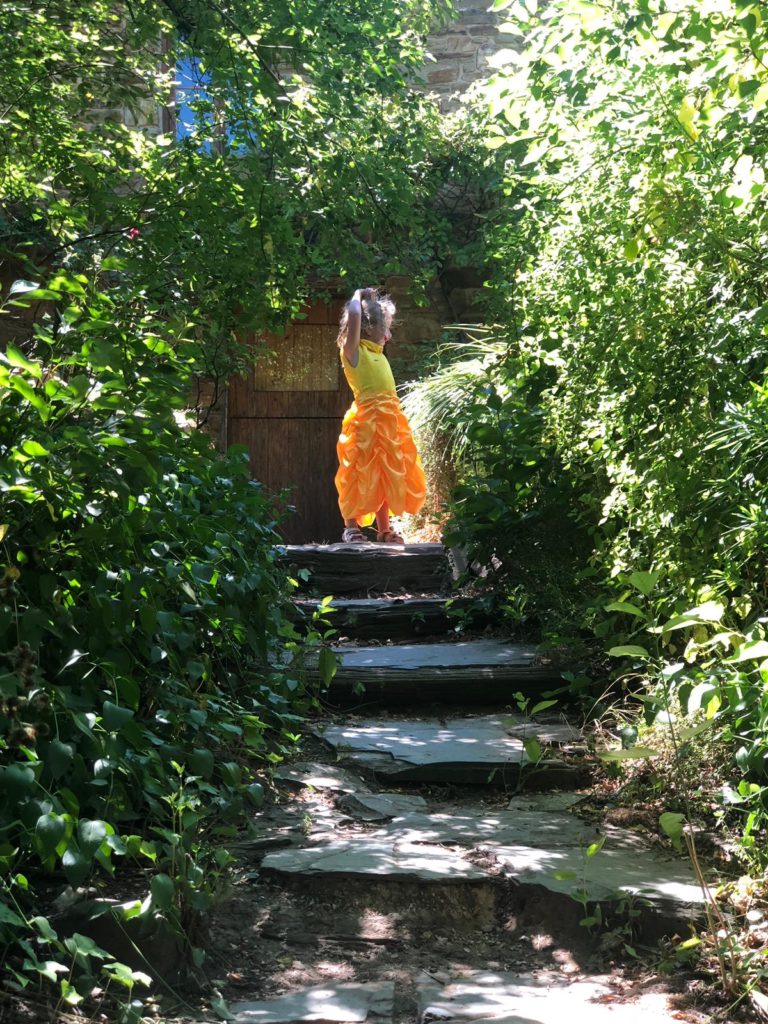 Child standing at the top of four steps outside