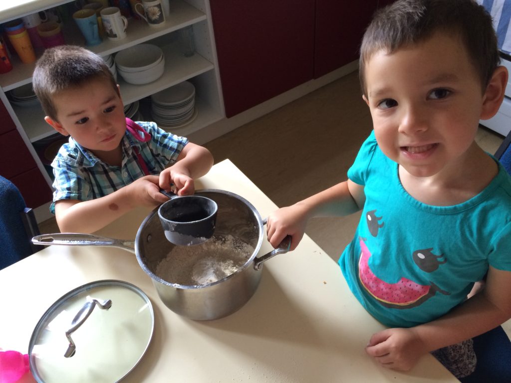 Two boys cooking. Cooking helps develop early math skills